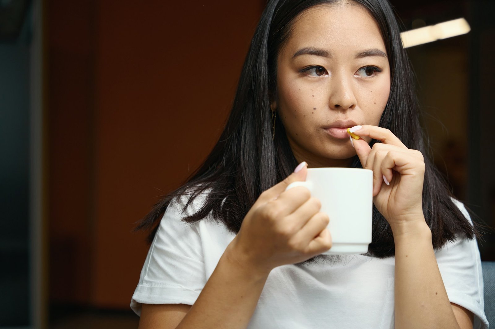 A sad Asian woman is feeling bad herself at work